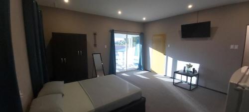 een slaapkamer met een bed en een glazen schuifdeur bij Waterland Suites in Paramaribo