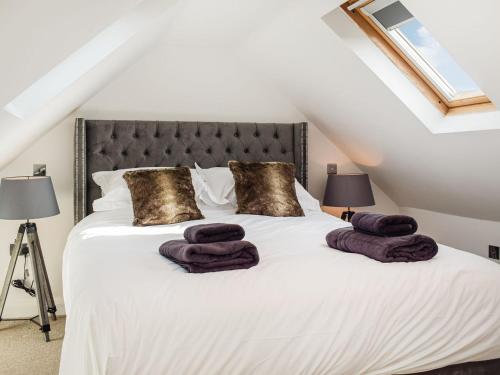 ein Schlafzimmer mit einem Bett mit lila Handtüchern darauf in der Unterkunft The Potting Shed in Preston Wynne