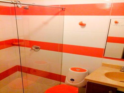 y baño con ducha, aseo y lavamanos. en Hotel Santris, en Duitama