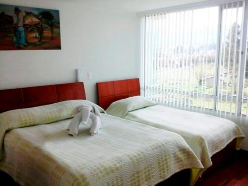 Un dormitorio con 2 camas y una toalla. en Hotel Santris, en Duitama