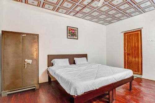 a bed in a bedroom with a wooden floor at Bluerock Resort in Tirupati
