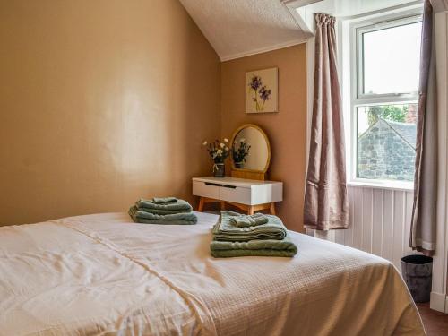 a bedroom with a bed with towels on it at Sunnyside in New Galloway
