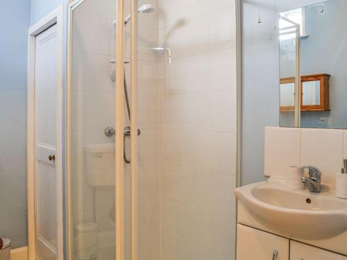 uma casa de banho com um chuveiro e um lavatório. em Sunnyside em New Galloway