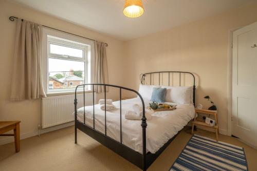 a bedroom with a bed and a window at 40 Buller Road - Aldeburgh Coastal Cottages in Leiston