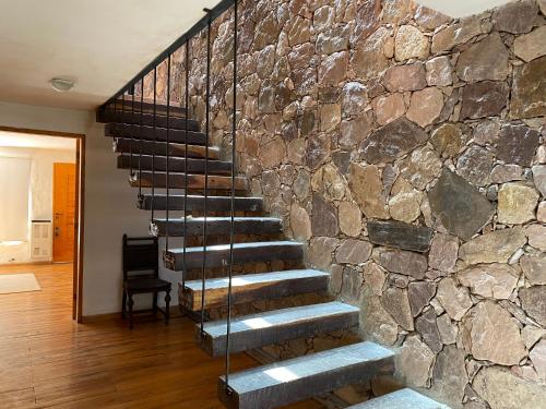 a stone wall with a staircase in a house at Chilcagua in Purmamarca