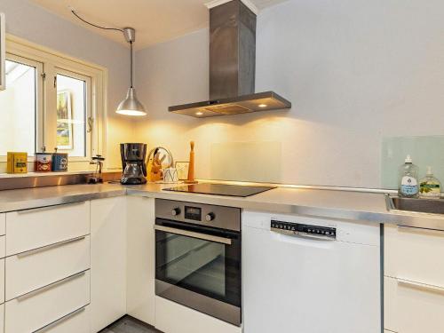 a kitchen with white cabinets and a stove top oven at 4 person holiday home in Rudk bing in Rudkøbing