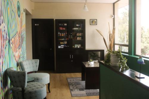 サカテカスにあるHotel Alikaの黒いキャビネットと椅子2脚が備わる客室です。