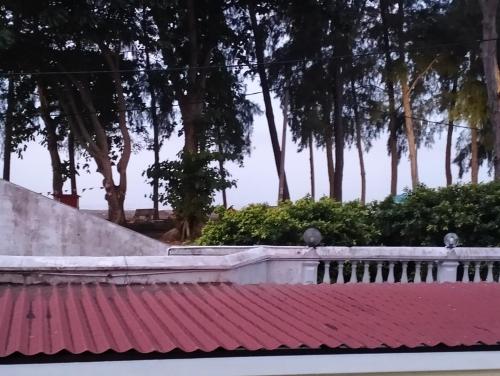 a red roof of a house with trees in the background at Pantai Puteri Kondominium in Kampong Bukit Darat