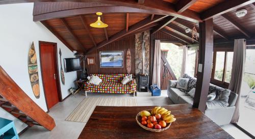 a living room with a bowl of fruit on a table at Casa Master frente da praia in Guarda do Embaú
