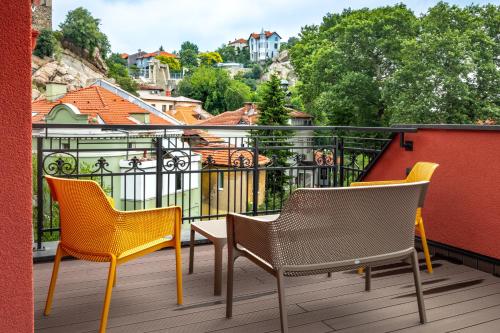 three chairs and a table on a balcony at Villa Flavia Heritage Boutique Hotel in Plovdiv