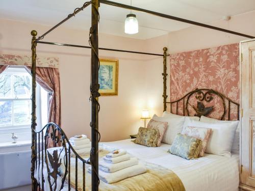 a bedroom with a four poster bed with towels on it at Staffield Cottage in Kirkoswald
