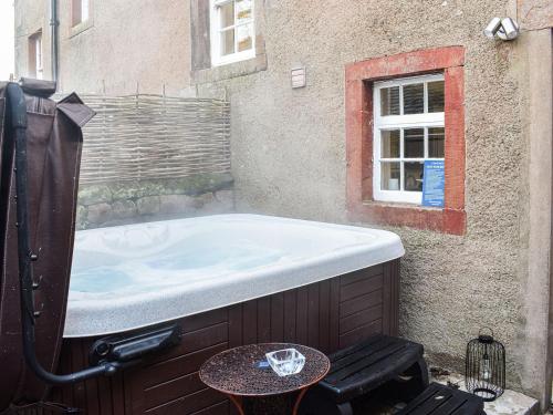 a large bath tub sitting next to a building at Staffield Cottage in Kirkoswald