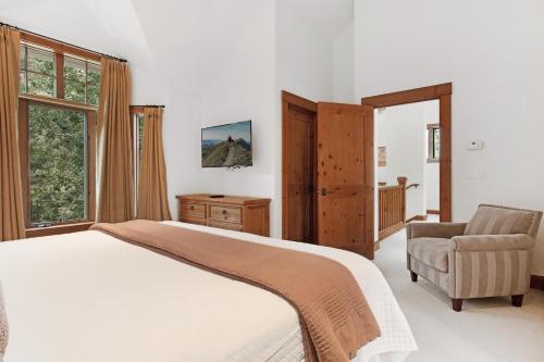 a bedroom with a bed and a chair and windows at 358 Cresta Road in Edwards