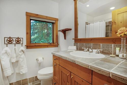 a bathroom with a sink and a toilet and a window at 358 Cresta Road in Edwards