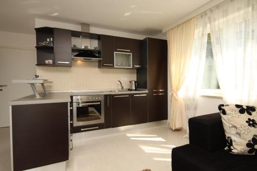 a kitchen with dark brown cabinets and a black chair at Apartments with a parking space Icici, Opatija - 7785 in Ičići