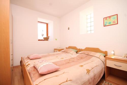 a bedroom with a large bed with pink pillows at Apartments with a parking space Cunski, Losinj - 8010 in Cunski