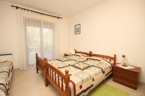 a bedroom with a bed and a table and a window at Apartments by the sea Cove Merascica, Cres - 8071 in Štivan