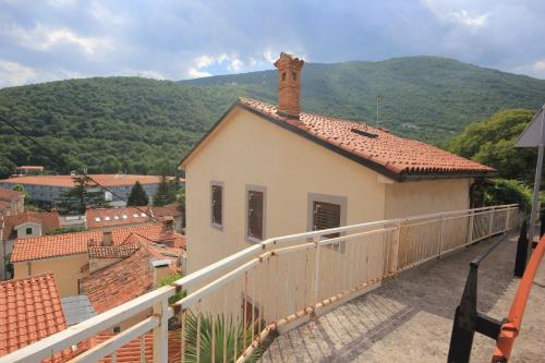 a balcony of a house with a mountain in the background at Apartments by the sea Moscenicka Draga, Opatija - 7906 in Mošćenička Draga