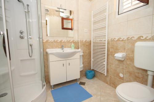 uma casa de banho com um lavatório, um chuveiro e um WC. em Apartments with a parking space Opatija - 7844 em Opatija