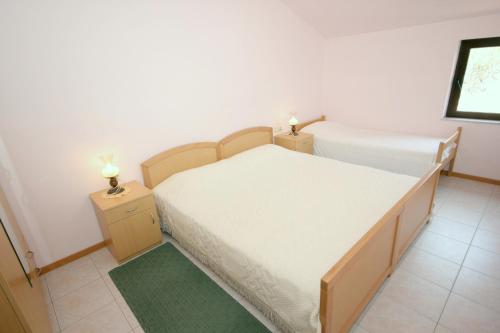 ein kleines Schlafzimmer mit einem Bett und zwei Nachttischen in der Unterkunft Apartments by the sea Cove Mala Lamjana, Ugljan - 347 in Kali