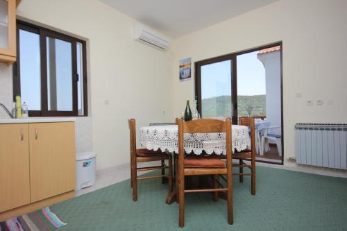 ein Esszimmer mit einem Tisch und eine Küche mit Fenstern in der Unterkunft Apartments by the sea Cove Mala Lamjana, Ugljan - 347 in Kali