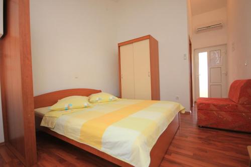 a bedroom with a bed with a mirror and a chair at Studio Pasman 8215a in Pašman