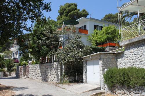 a house with a stone wall and a garage at Double Room Mali Losinj 7953a in Mali Lošinj