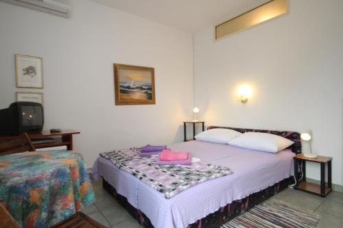 a bedroom with a bed and a tv in it at Double Room Mali Losinj 7953a in Mali Lošinj