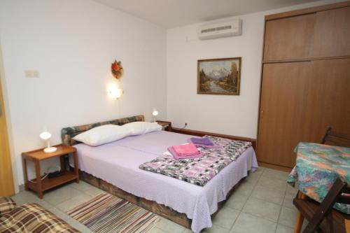 a bedroom with a bed and a table and a chair at Studio Mali Losinj 7953a in Mali Lošinj