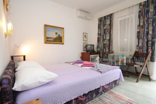 a small bedroom with a bed and a chair at Double Room Mali Losinj 7953b in Mali Lošinj