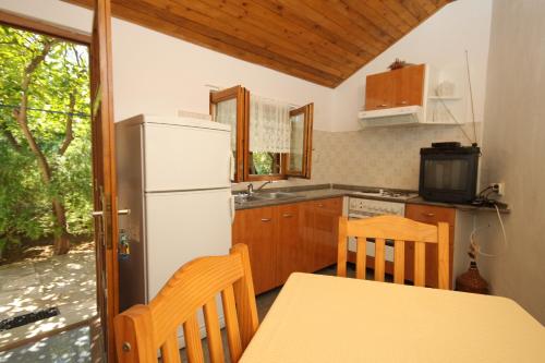 a kitchen with a refrigerator and a table and chairs at Apartments with a parking space Mali Losinj (Losinj) - 8059 in Mali Lošinj
