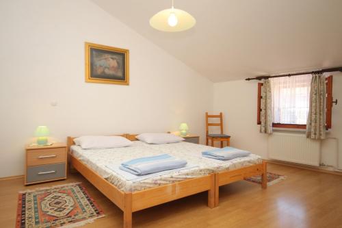 um quarto com uma cama com duas almofadas em Apartments by the sea Osor, Losinj - 8088 em Nerezine