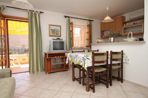 uma cozinha e sala de jantar com mesa e cadeiras em Apartments by the sea Osor, Losinj - 8088 em Nerezine
