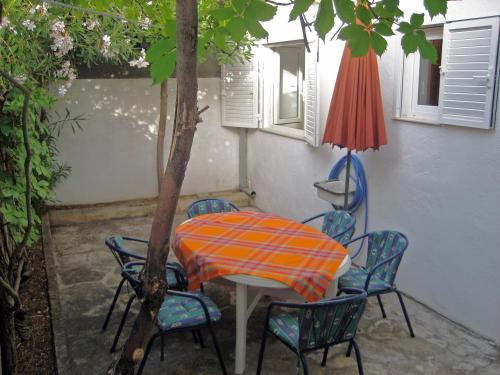 - une table et des chaises avec un parasol sur la terrasse dans l'établissement Apartments with WiFi Bol, Brac - 8736, à Bol