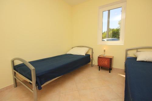 sypialnia z dwoma łóżkami i oknem w obiekcie Apartment Opric 7716b w mieście Lovran