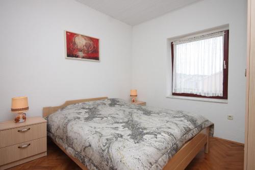 Un dormitorio con una cama grande y una ventana en Apartments by the sea Mali Losinj (Losinj) - 7974 en Mali Lošinj