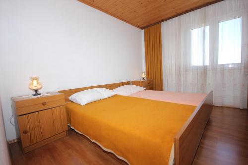 a bedroom with a large bed and a window at Apartments by the sea Zaglav, Dugi otok - 8191 in Sali