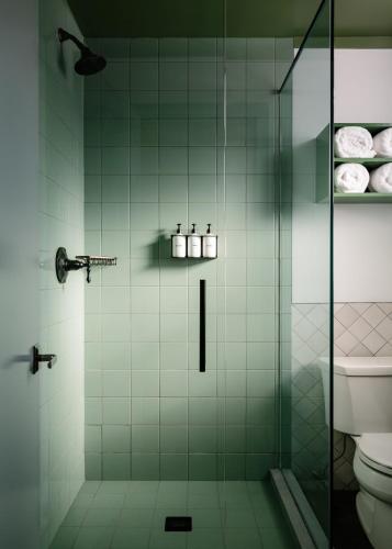 a bathroom with a glass shower with a toilet at Daunts Albatross Motel in Montauk