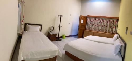 a hotel room with two beds and a window at Ha Ke Stay in Chishang