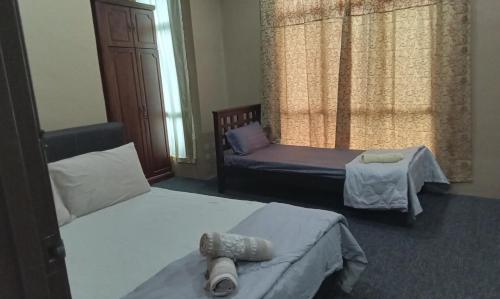 1 dormitorio con 2 camas, sofá y ventana en NZ Villa Roomstay, en Kangar