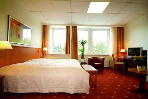 a hotel room with a bed and a desk and window at Traveller Hotel in Lübeck