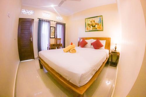 una camera da letto con un letto con un orsacchiotto sopra di Witantra house ad Ubud