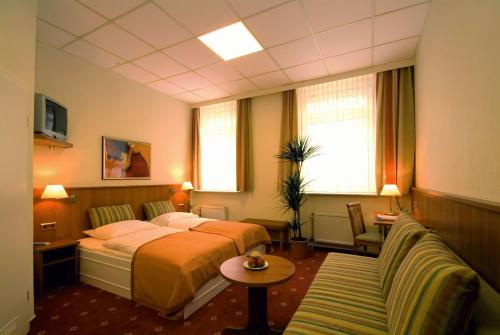 ein Hotelzimmer mit einem Bett und einem Sofa in der Unterkunft Traveller Hotel in Lübeck