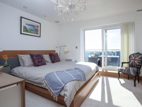 a bedroom with a large bed and a large window at The Penthouse - Clearview in Newquay