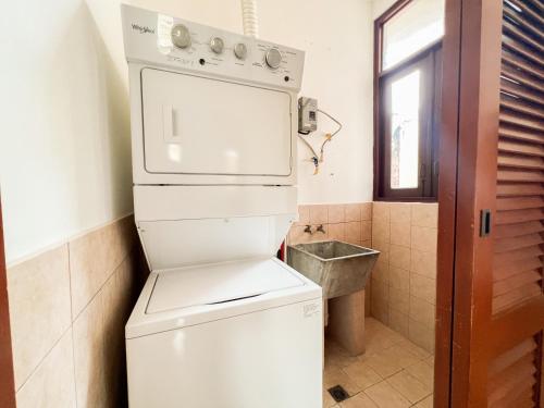 uma pequena casa de banho com máquina de lavar e secar roupa em Apartamento en el Corazón de Casco Viejo Panamá 10 na Cidade do Panamá