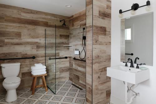 a bathroom with a shower and a toilet and a sink at Daunts Albatross Motel in Montauk