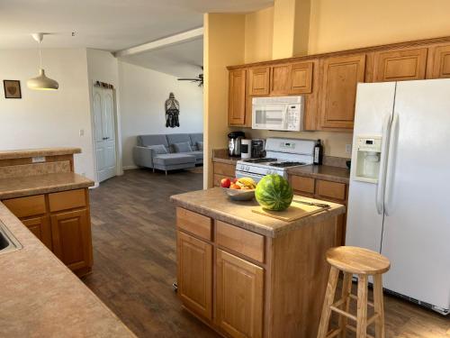 a kitchen with wooden cabinets and a white refrigerator at Bodhi House, Joshua Tree National Park in Twentynine Palms