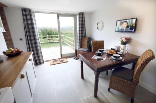 a kitchen and dining room with a table and chairs at Moorland View Lodge in Baslow
