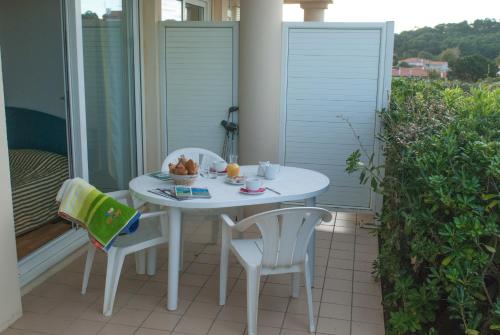 a white table and two chairs on a balcony at Résidence Mer & Golf Eugénie in Biarritz