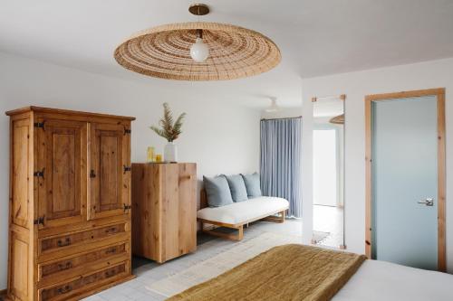 a bedroom with a bed and a dresser and a chair at Daunts Albatross Motel in Montauk